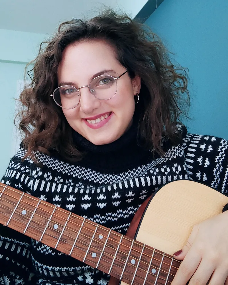 Akustik gitarıyla gülümseyen İpek Bolakca